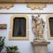 Il piano terra, sul quale si aprono i due ingressi al Palazzo,  abbellito dalle seicentesche statue in pietra dei santi Pietro...